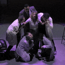 a group of people standing around a woman on a stage