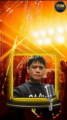 a man stands in front of a crowd with a microphone in front of him and a sign that says sgm