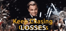 a man in a tuxedo is smiling and giving a thumbs up with the words keep chasing losses behind him .
