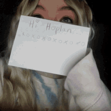 a woman is holding a piece of paper that says hi hoplan