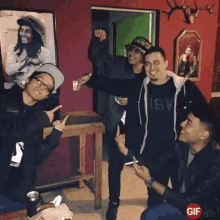a group of young men are posing for a picture in a room with a picture of bob marley in the background .