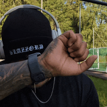 a man wearing headphones and a black beanie that says blazord