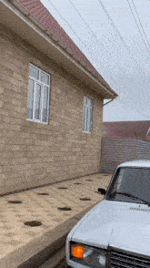a white car is parked outside of a brick building