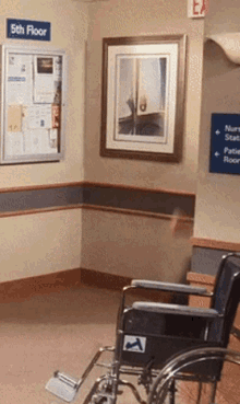 a wheelchair is sitting in a hallway with a sign that says 5th floor