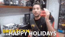a man sitting in front of a desk with the words " happy holidays " on the bottom