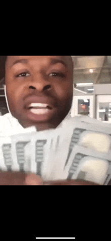 a man is holding a bunch of money and smiling