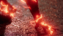 a close up of a person 's feet with red lightning coming out of them .