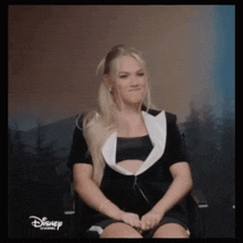 a woman is sitting in a chair with the word disney on the bottom right