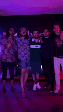 a group of young men posing for a picture with one wearing a shirt that says ' puma ' on it