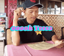 a man sitting at a table reading a menu with the words oooh yeess written above him