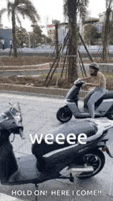 a man is riding a scooter on a sidewalk next to a motorcycle .