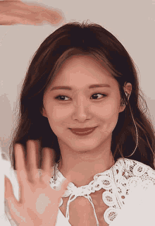 a close up of a woman wearing a white lace shirt