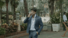 a man in a suit is talking on a cell phone