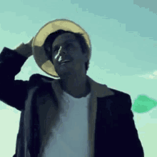 a man wearing a cowboy hat is standing in front of a blue sky .