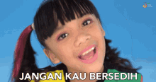 a little girl is smiling and the words jangan kau bersedih are behind her