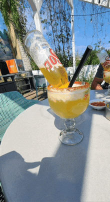 a large margarita with a bottle of dos equis in it