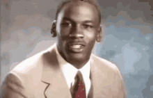 michael jordan is wearing a tan suit and tie .