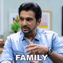 a man in a denim shirt has the word family written on his shirt