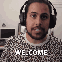 a man wearing headphones and a shirt that says welcome