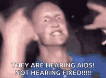 a man making a funny face with the words they are hearing aids not hearing fixed !!!