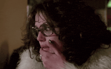 a close up of a woman wearing glasses and a white fur coat