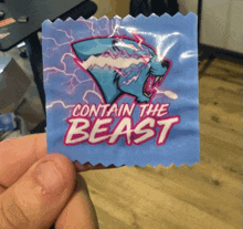 a person is holding a blue condom that says contain the beast