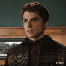 a man wearing a sweater and a plaid jacket with netflix written on the bottom