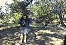 a man with long hair is riding a bike in a park .
