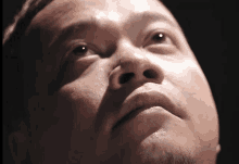 a close up of a man 's face looking up at something