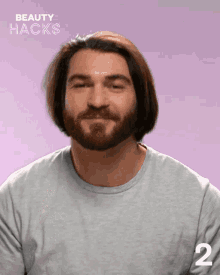 a man with a beard wearing a grey shirt with the number 2 on the bottom
