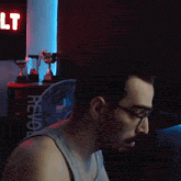 a man wearing glasses is sitting in front of a sign that says revol