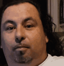 a close up of a man 's face with a beard and long hair