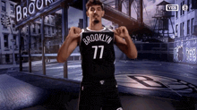 a man in a brooklyn 77 jersey is flexing his muscles