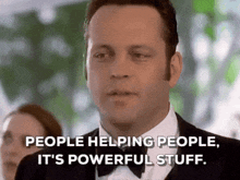 a man in a tuxedo and bow tie is talking about helping people .