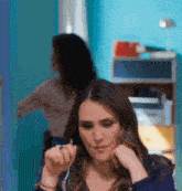 a woman is looking at herself in the mirror