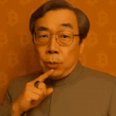 a man wearing glasses is pointing at his mouth and saying `` one hundred billion dollars '' .