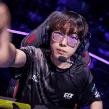 a man wearing glasses and headphones with the letters edx on his shirt