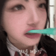 a girl in a school uniform is brushing her teeth with a toothbrush