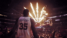 a basketball player wearing a number 35 jersey stands in front of fireworks