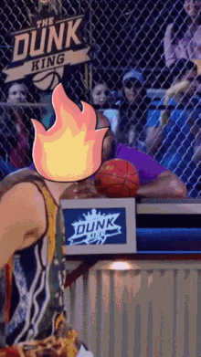 a basketball game is being played in front of a sign that says " the dunk king "