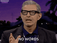 a man wearing glasses says " no words " in front of a purple background