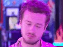 a close up of a man 's face with a purple background