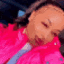 a blurry picture of a woman in a pink jacket and tie .