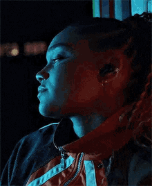 a close up of a woman leaning against a wall in a dark room .