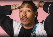 a man with dreadlocks and a beard is holding his head in his hands