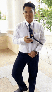 a man wearing a white shirt and black pants is standing in front of a vivavideo sign