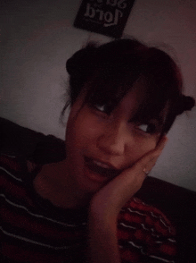 a girl laying on a couch with her hand on her face in front of a sign that says jolly