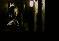 a woman is standing in a dark room holding a blanket