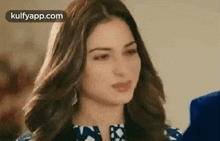 a close up of a woman 's face with a blue shirt on .