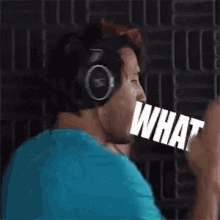 a man wearing headphones is holding the word what in his mouth .